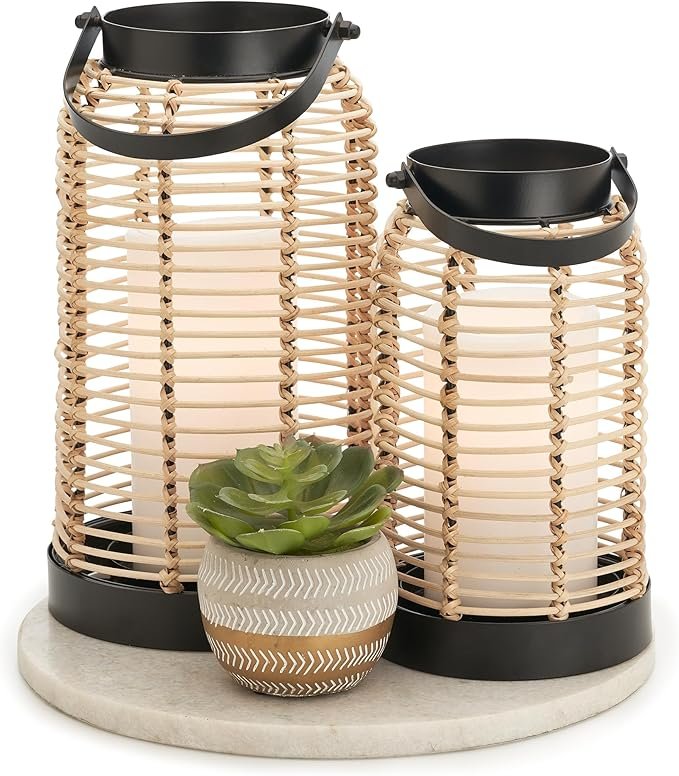 Two woven rattan lanterns with black metal frames and a small potted succulent on a round marble tray for Japandi-style home decor.