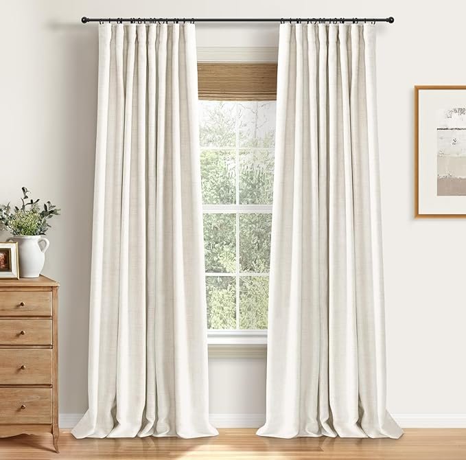 Floor-length cream linen blackout curtains on black curtain rod, adding softness and warmth to a Japandi bedroom.