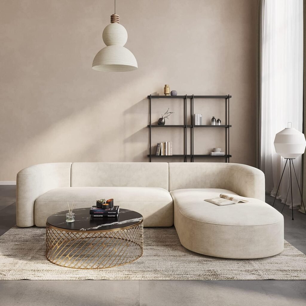 Minimal Japandi living room with a cream curved sofa, black shelving, and a round black marble coffee table.