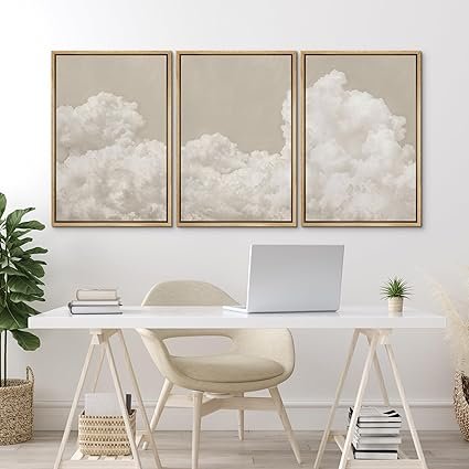 Set of three neutral cloud wall art prints framed in natural wood, styled above a minimalist white desk.