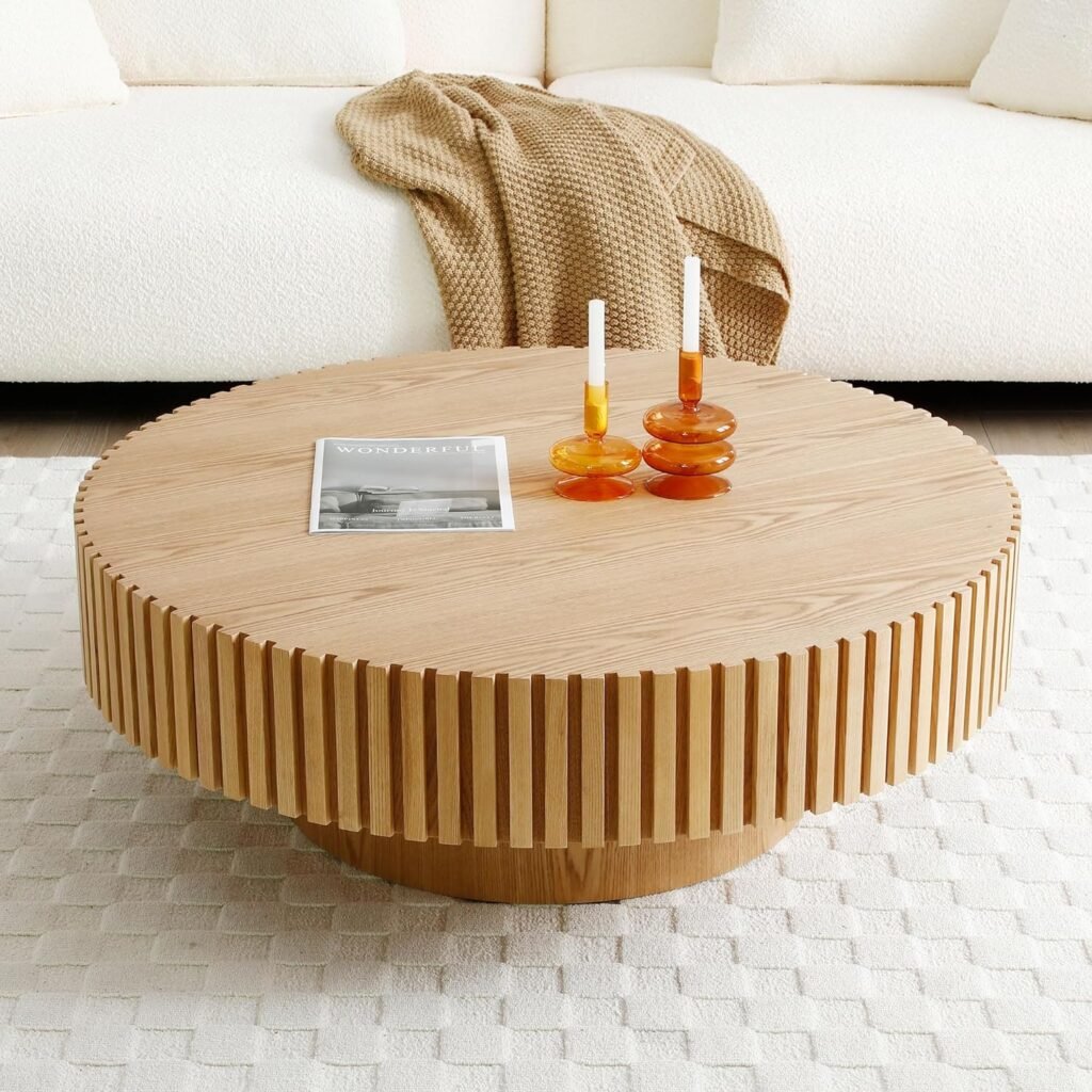 round fluted wood coffee table with vertical detailing styled with modern candlesticks in neutral room