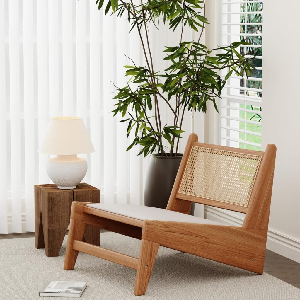 Low wooden Japandi lounge chair with woven cane backrest and neutral seat cushion beside a small side table and lamp.