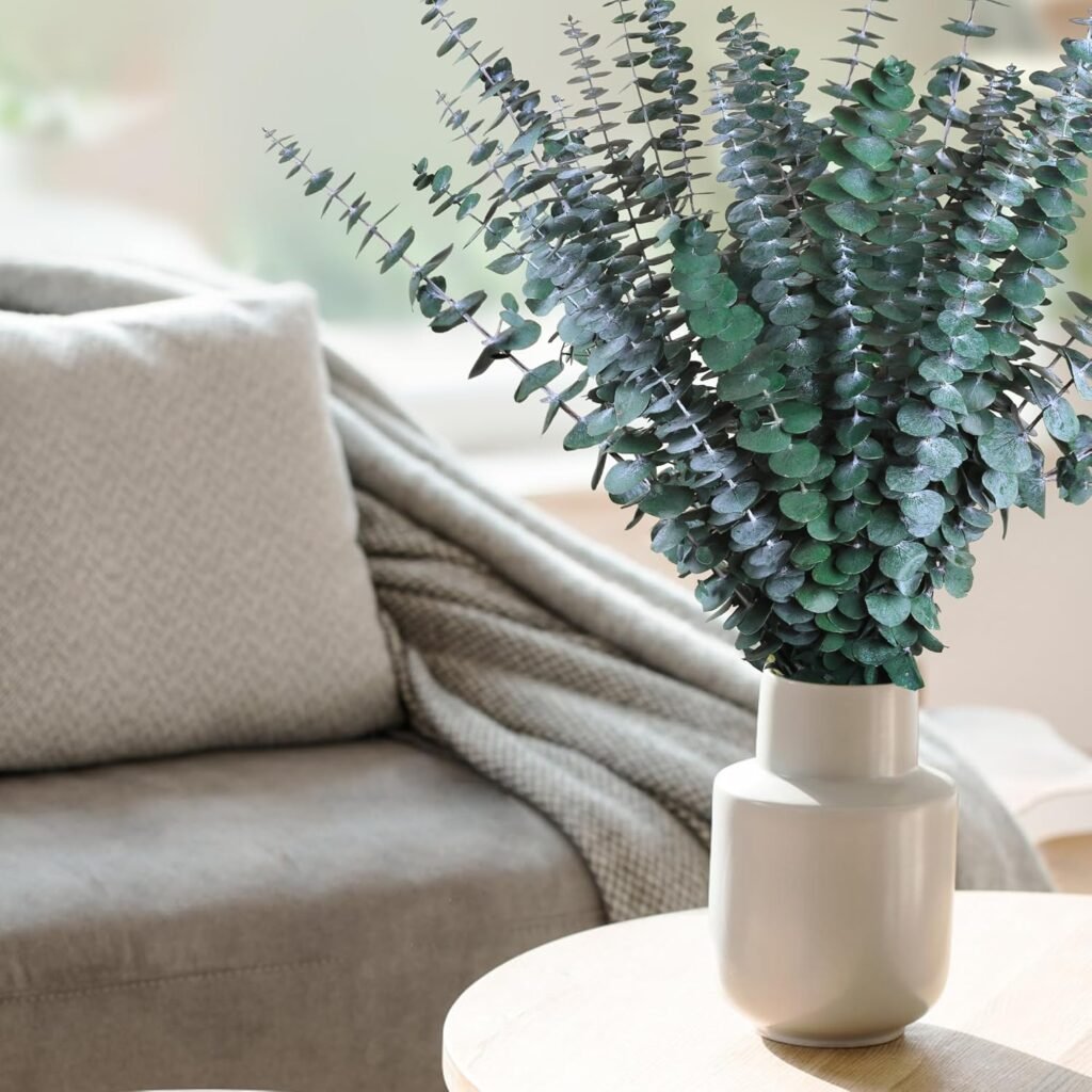 ceramic vase filled with dried eucalyptus stems, styled on a wooden table for Japandi home decor.