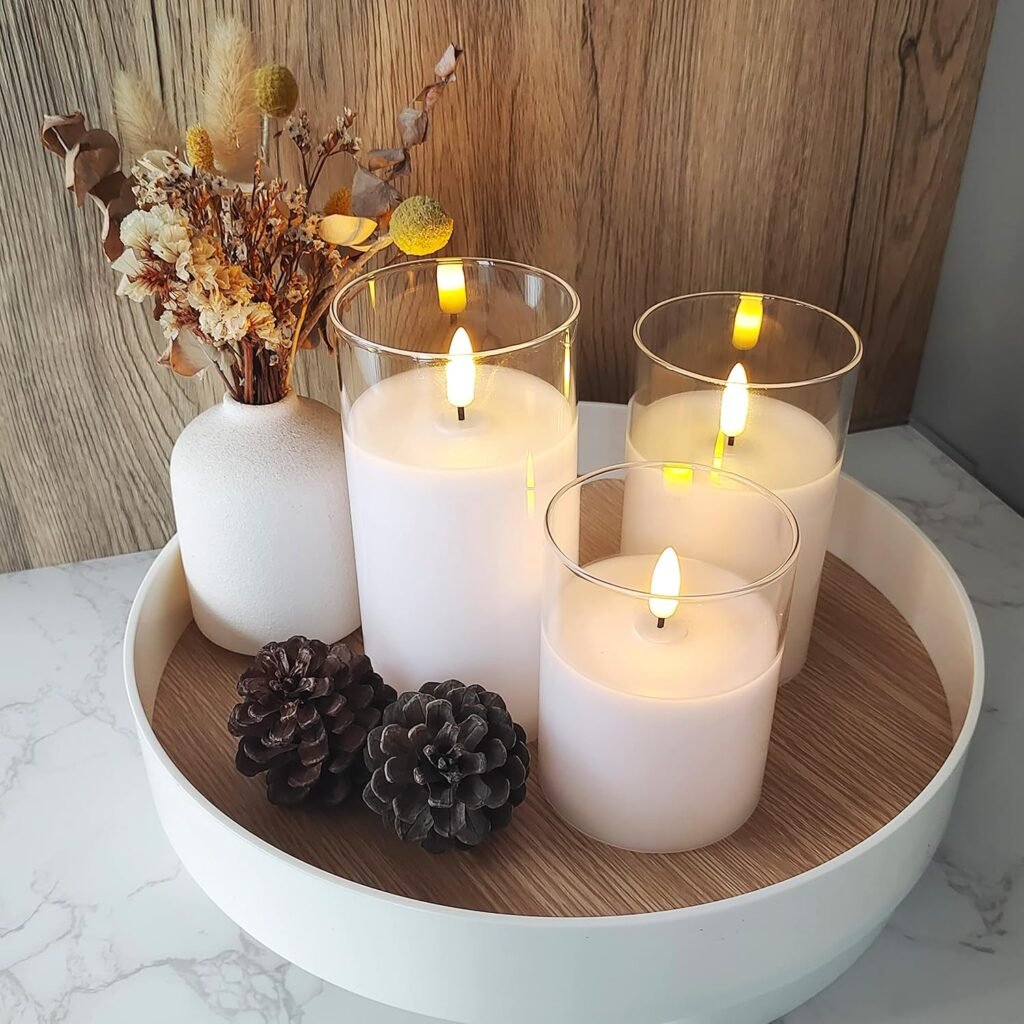 fall candle display with white pillar candles, pinecones, and dried stems on round tray