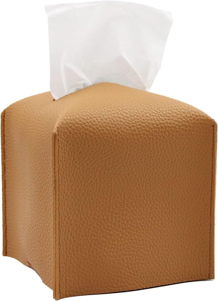 Caramel brown faux leather tissue box cover with white tissues peeking out, modern fall home accessory.